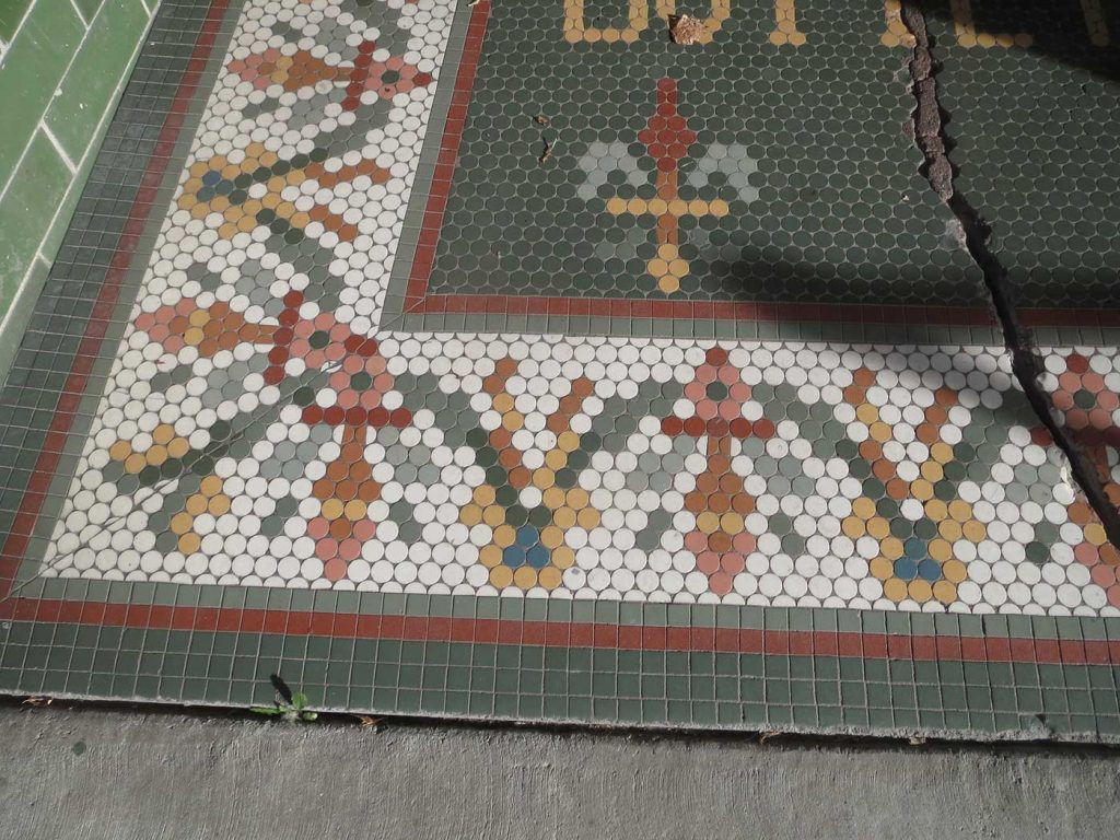 Closeup of the Butte Floral border, intriciate tile in arches of greens, gold, red on white background