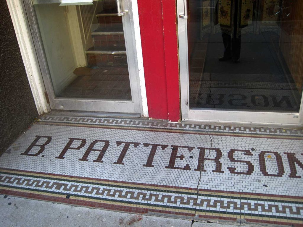 B Patterson tile letters in green, white background, multicolored border with zigzag pattern