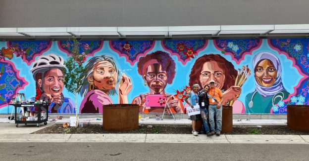 Artist Hend al-Mansour poses with her outdoor mural.