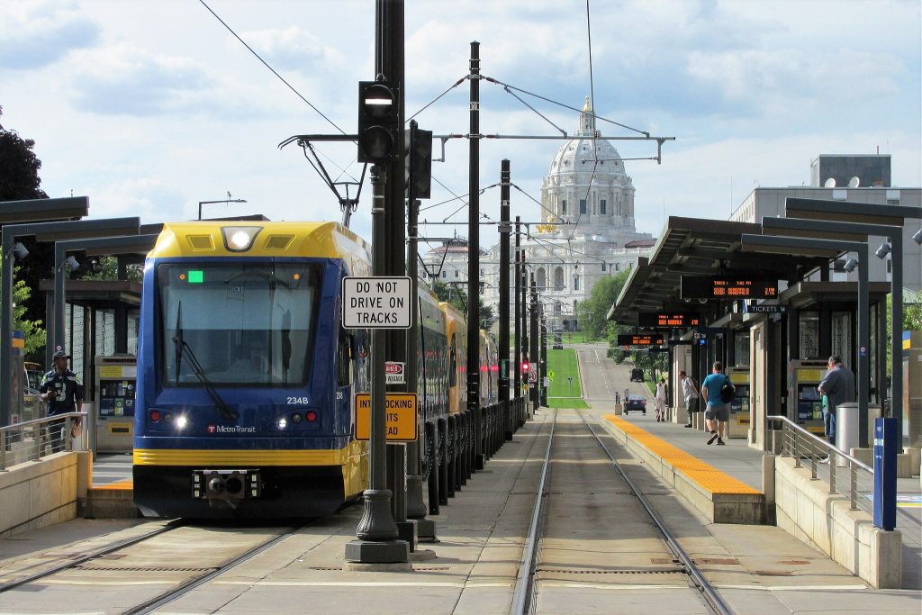 A Green Line train at a station with the capitol building in the background