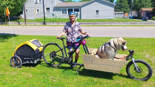 Risa poses with the setup, beaming in the sun. Bandit is ready for the group to get rolling already.