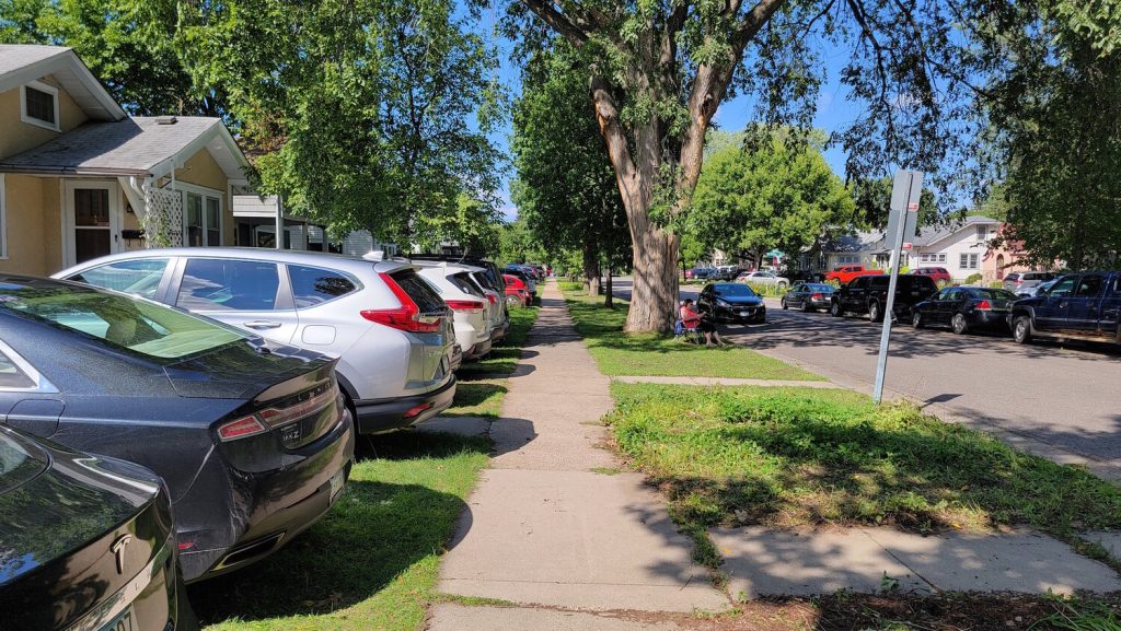 Cars parked in front lawns in a neighborhood near the Minnesota State Fair.