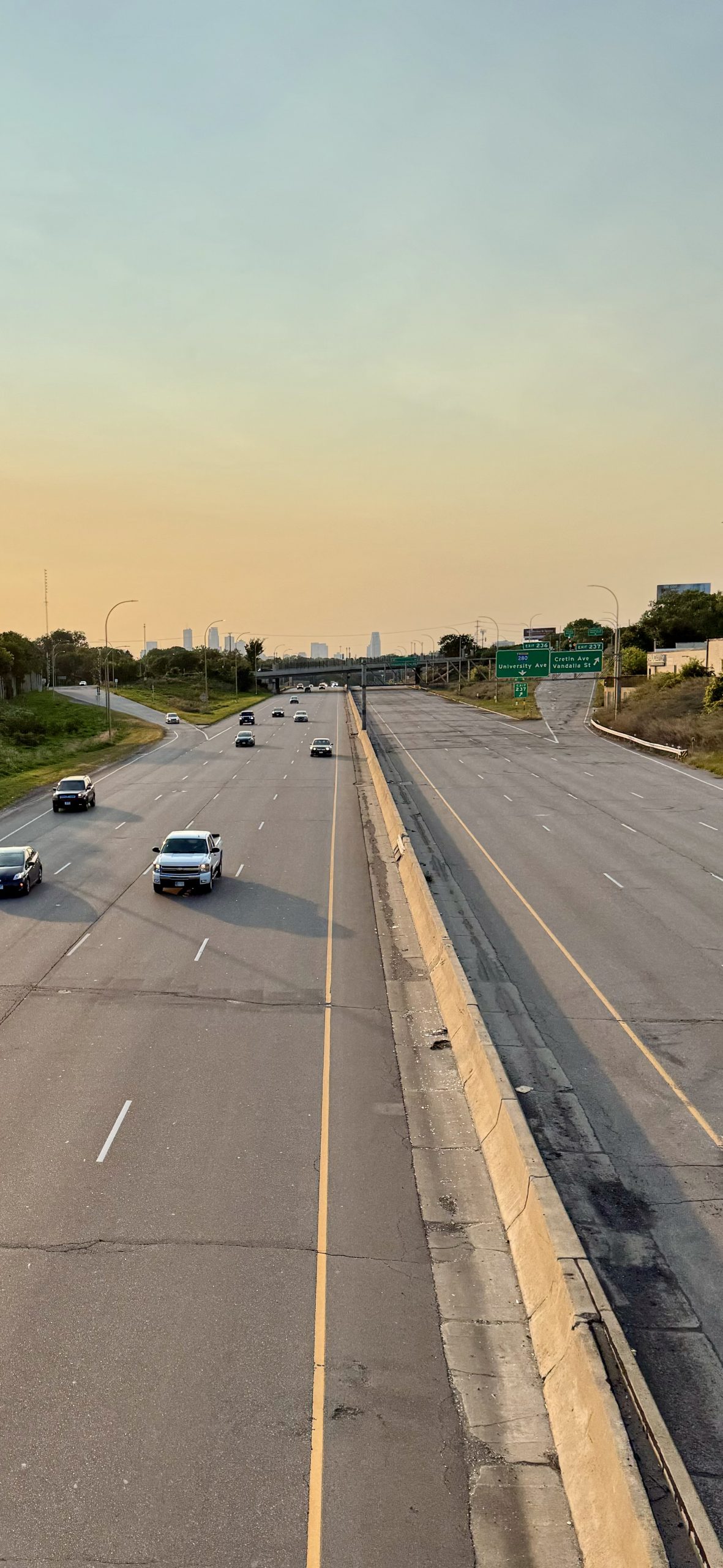 I-94 while closed  to westbound traffic at sunset. There are several cars and trucks on the left side of the highway, while the right side of the highway is empty.