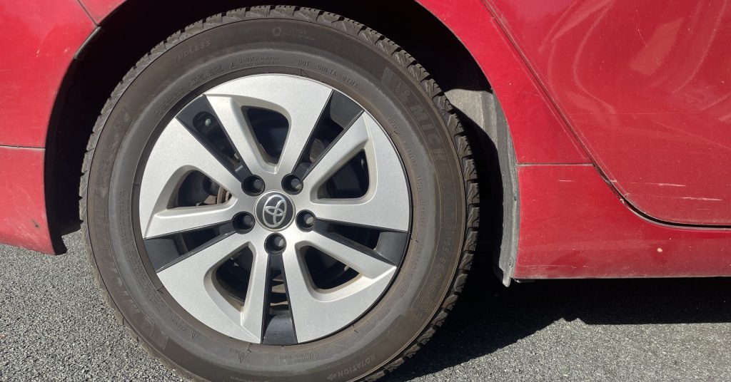 Car tire on asphalt roadway.