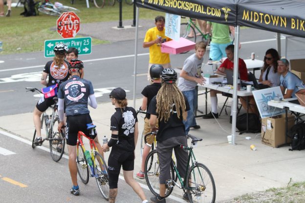 Cyclists gather by a station along the Midtown Greenway.