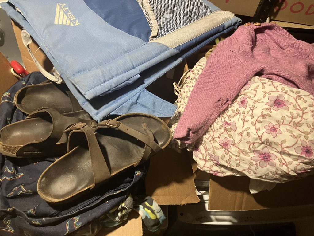 A collection of old sandals, camping equipment and clothing.