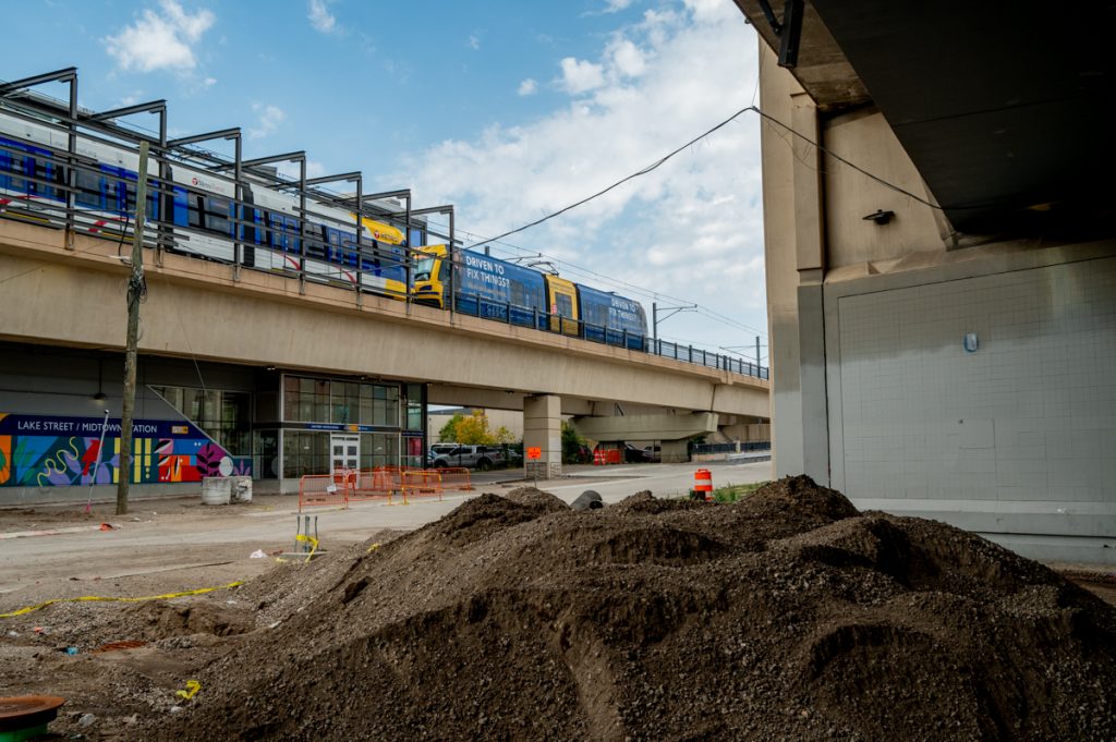 A train at the elevated Lake Street Station, as seen from a construction site at street level.