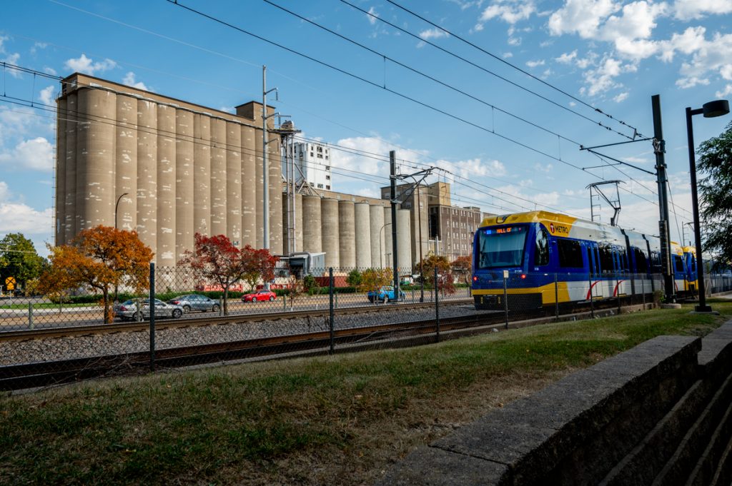 A Blue Line Train with another set of grain elevators in the background.