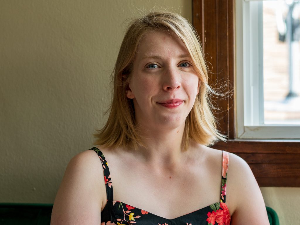 A smiling young woman looks at the camera.