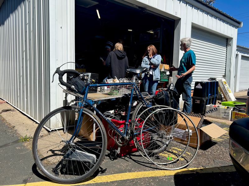 The one and only Mr. Michael helping customers in his garage full of bike parts