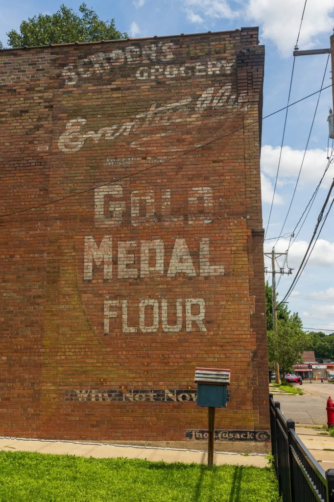 Fading signs on the side of the brick building at 171 Front Avenue