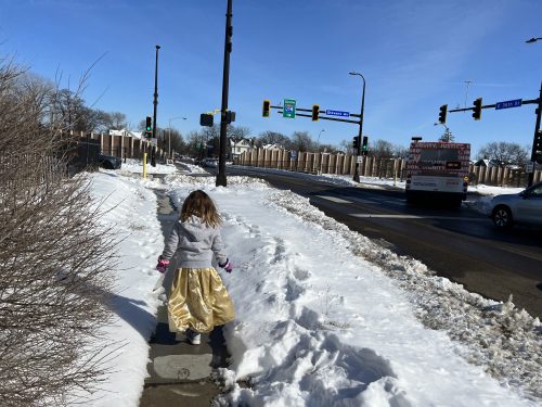 A person walking on a snowy sidewalk.