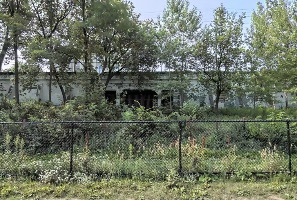 Looking south at 29th St supported by concrete retaining walls and a gated off concrete bridge.