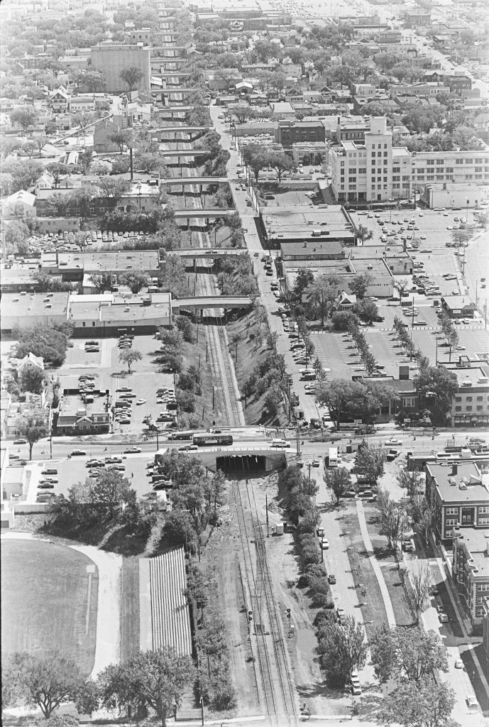 Aerial photograph of the rail corridor showing the new Hennepin Avenue bridge under construction, and 15 bridges further away all of the same design.