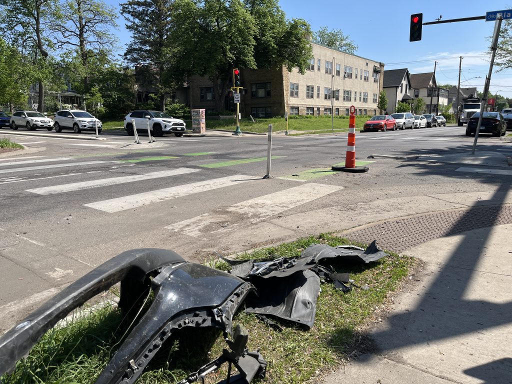 This photo shows the intersection of 35th Street and Blaisdell Avenue South, where the two-way bike lane passes through the corridor. There's a significant chunk of a car bumper placed in the tree boulevard, the remnants of some kind of crash.