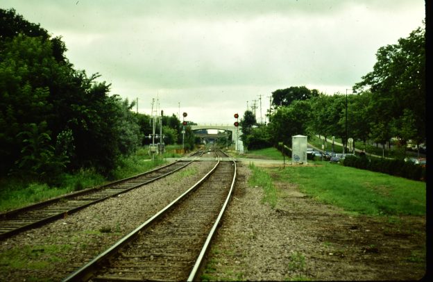 Looking east into the 29th Street corridor with two railroad tracks curing into the "tunnel" of bridges.