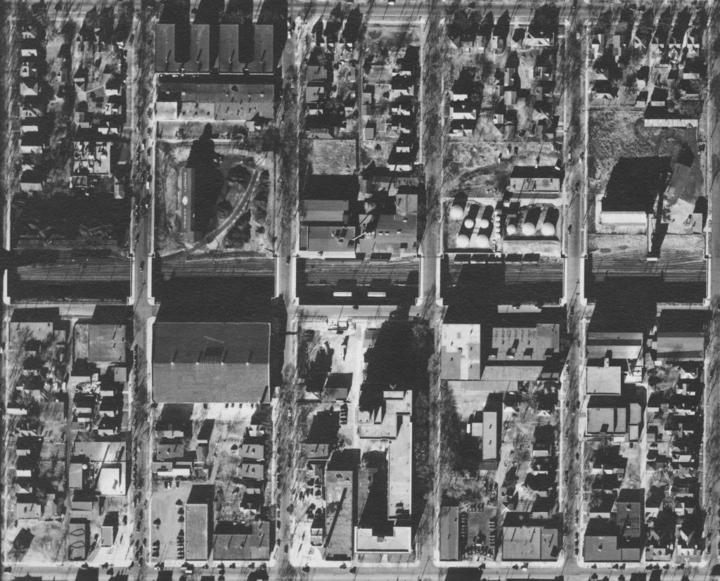 Aerial photograph from 1938 showing a curved railroad spur going North into the industry between Emerson and Dupont avenues.