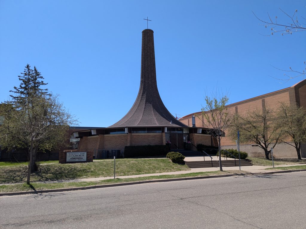 round church with roof and steeple integrated like the bell of a horn