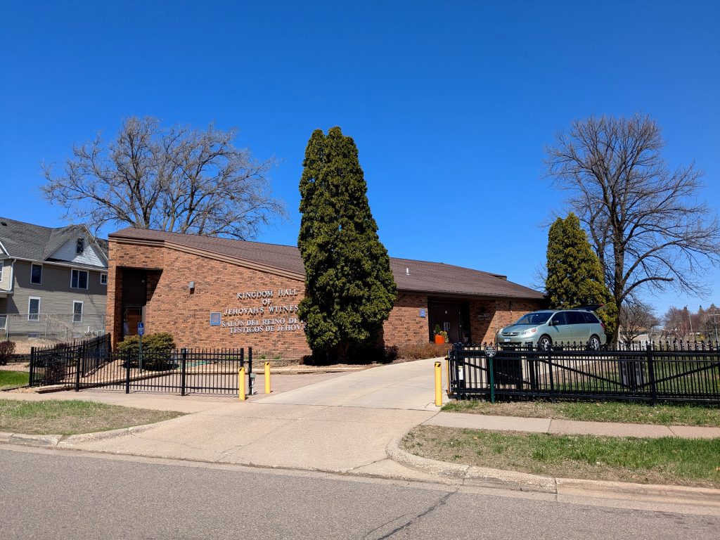 single-story brick building with pitched roof and angular side entrance