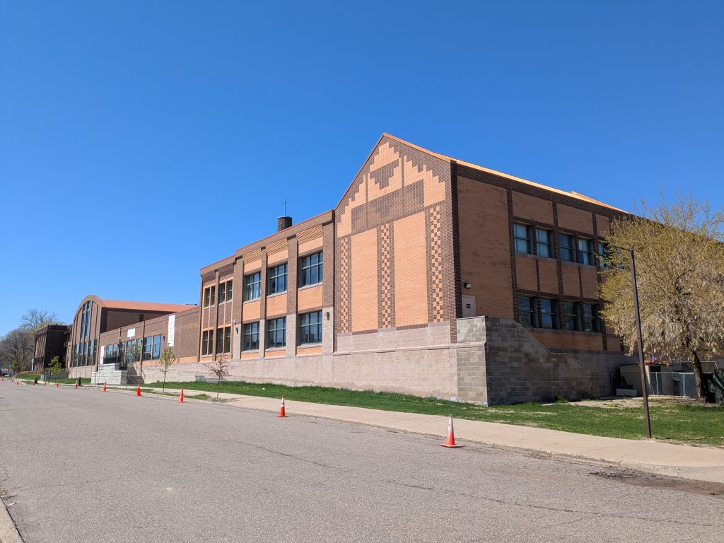 extended brick building with one-and two-storied sections with varied rooflines: gabled, flat, and barrel-vaulted