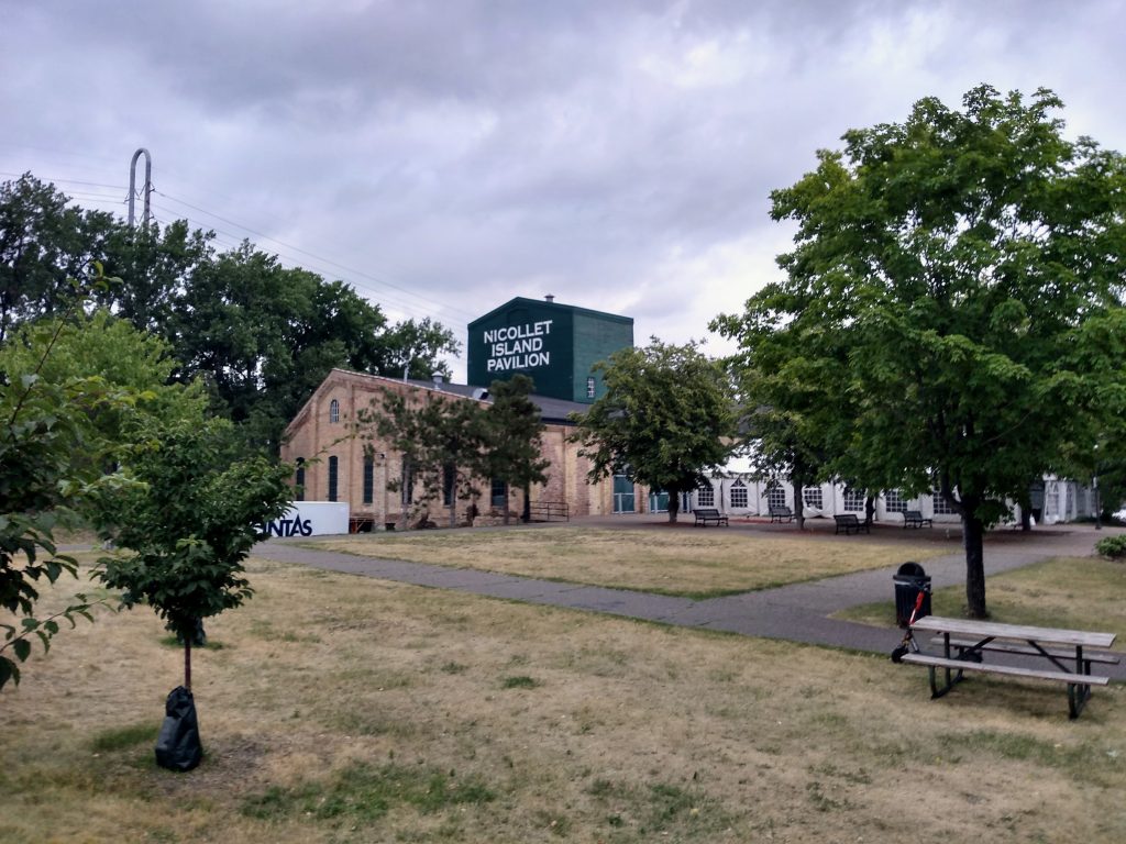 building labeled Nicollet Island Pavillion with grassy area in foreground