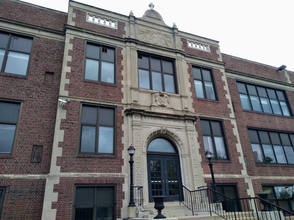 brick and concrete school topped by cross