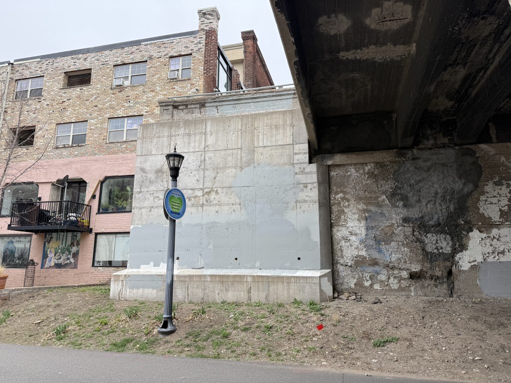 Northwest wing wall with new concrete in front at the Pleasant Avenue S bridge.
