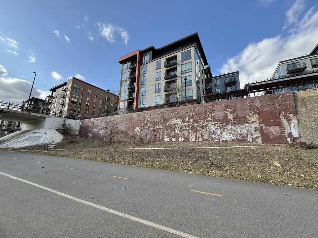 Retaining wall with filled in old windows to the North side of the corridor to the east of Dupont Avenue.