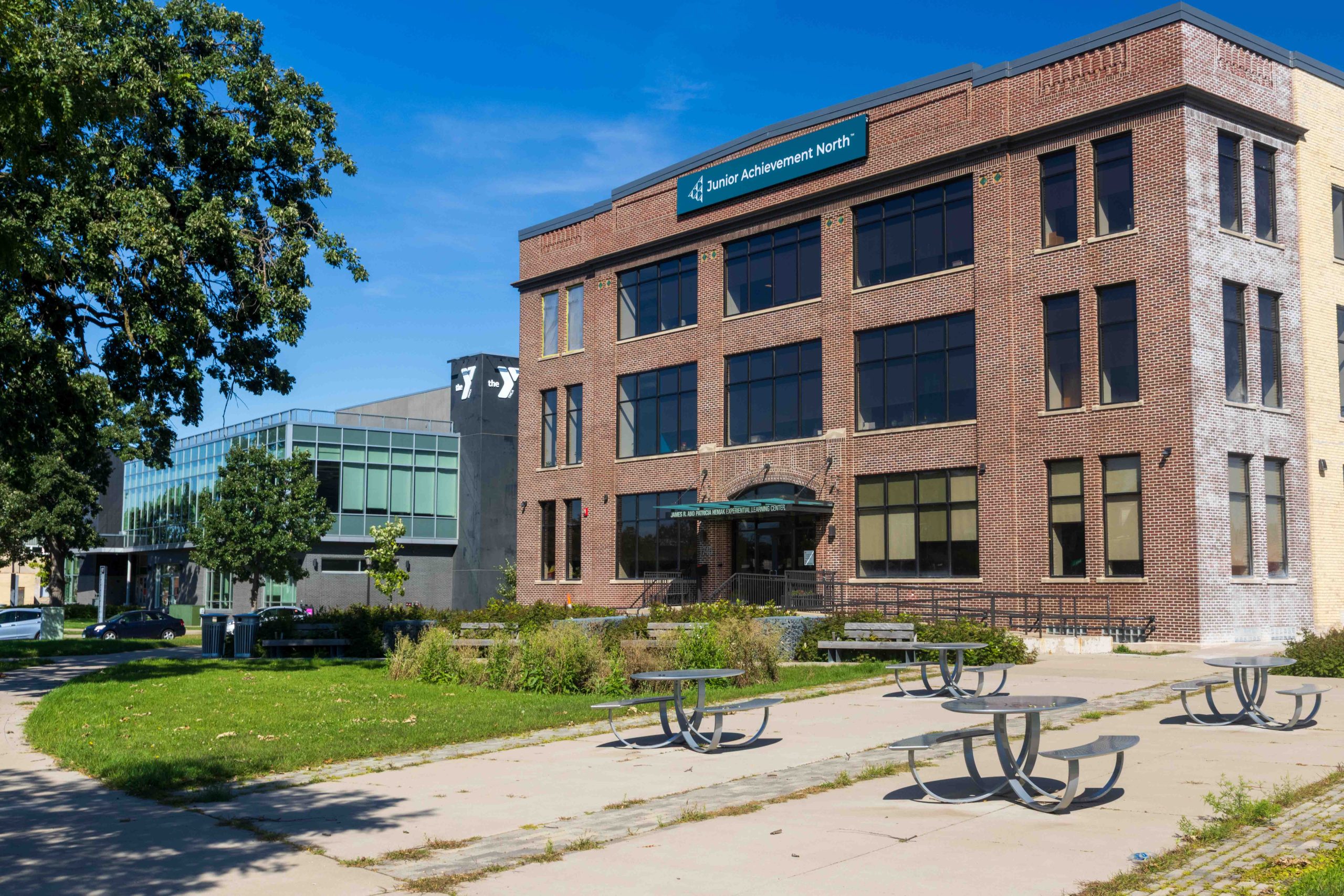 Picnic tables, benches and lawn in front of Dickerman Park in front of the historic Brown, Blodgett and Sperry building that’s home to Junior Achievement.