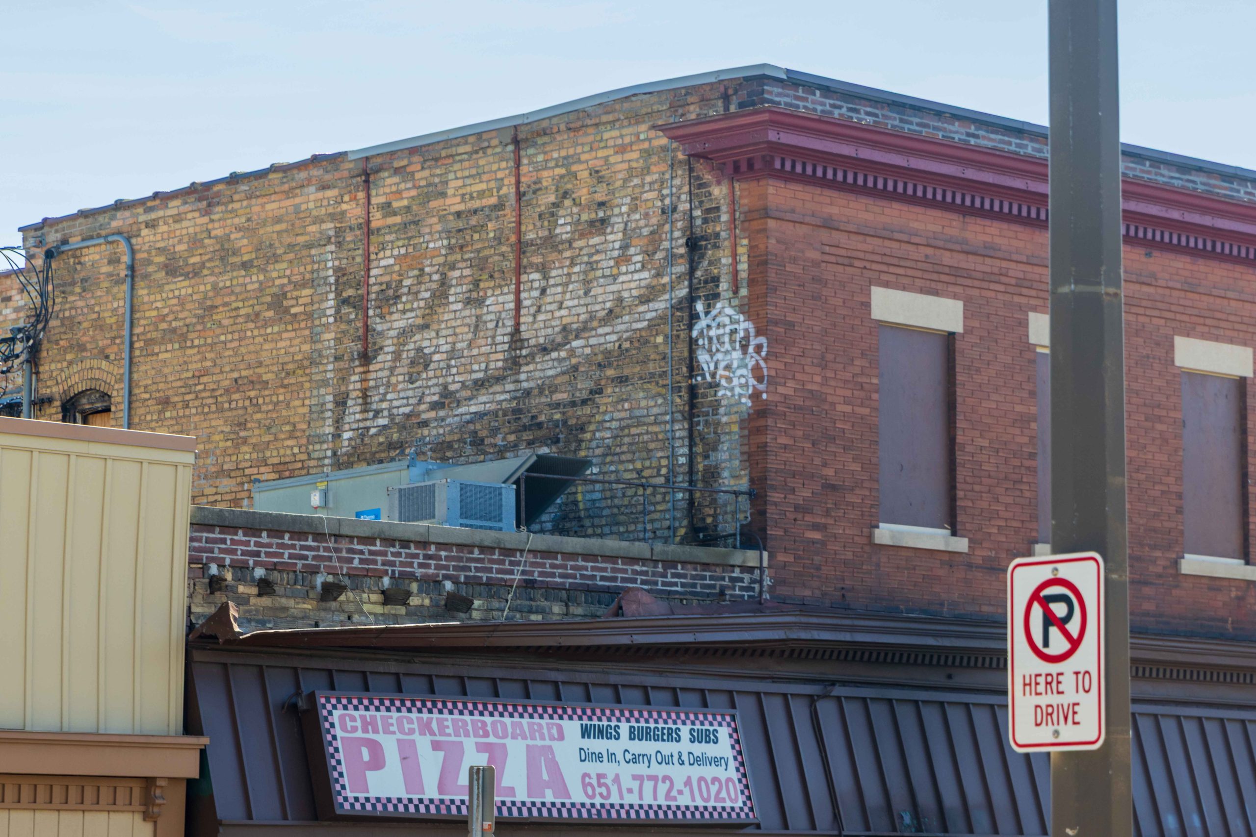 On the north side of the former Checkerboard building, a “ghost sign” for Schmidt Beer clings to the brick.