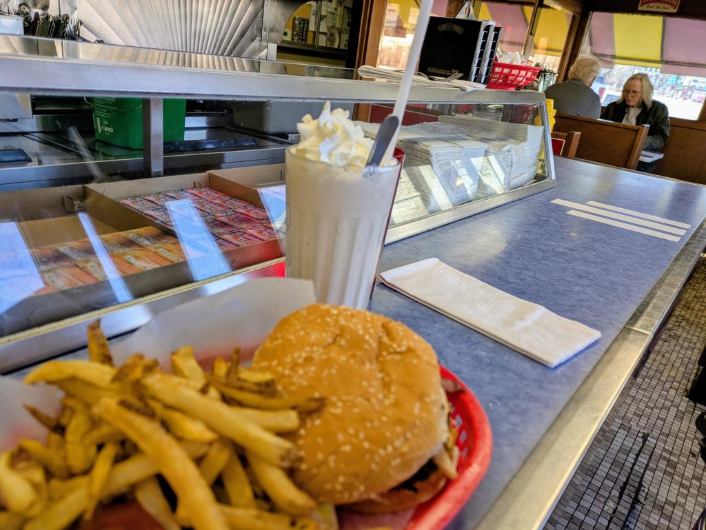 A classic hamburger, fries, and shake lunch at the counter of Mickey’s Diner