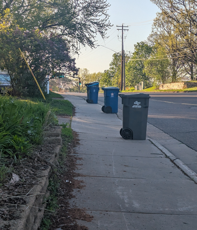 Sidewalk with garbage cans blocking part of the sidewalk on Cedar Lake Road.