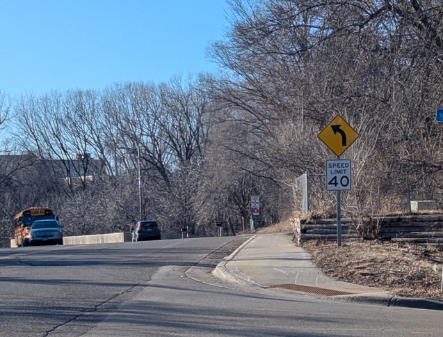 Intersection of Ford Road and Cedar Lake Road showing a curb cut and 40 MPH speed limit sign. 