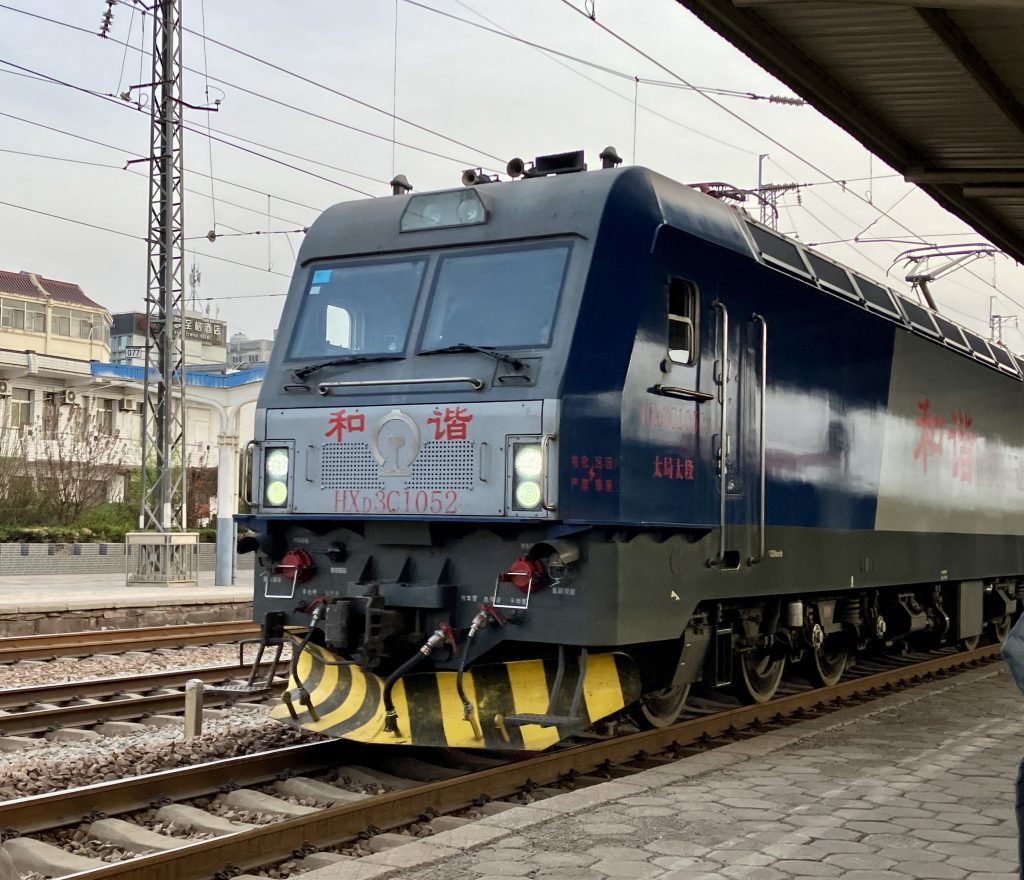 Locomotive train pulling at station.
