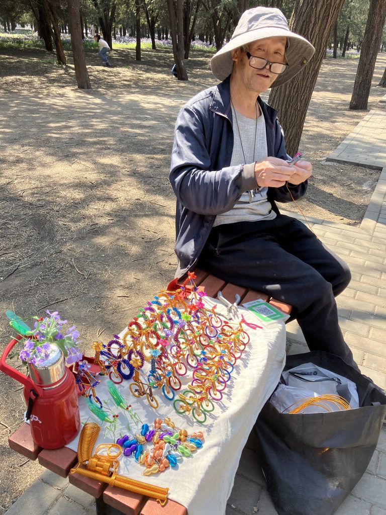 A craftsman selling small bicycles and other assorted handmade trinkets