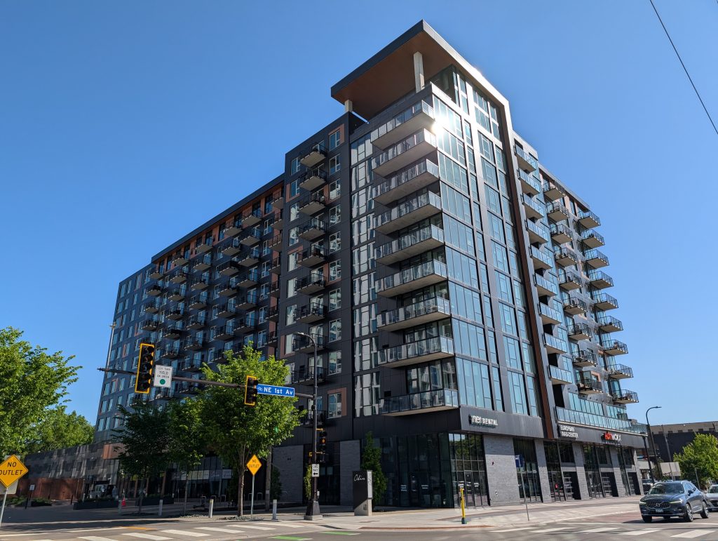 Contemporary apartment building featuring glass curtain wall and arrays of patios.