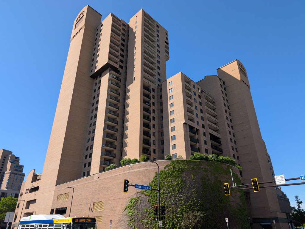 Highrise building made of tan brick with patios.