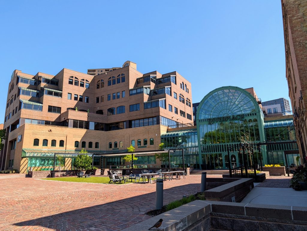 Terraced building with large glazed entryway topped with an arch.