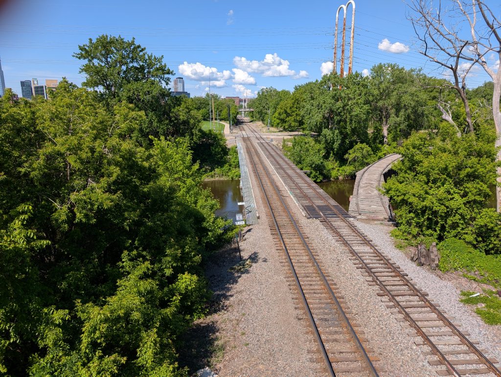 Railroad bridge with two tracks and a disconnected stub of a third track curving off to the right.