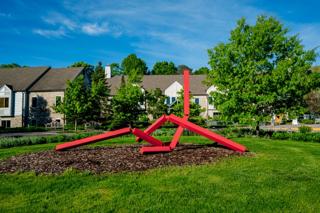 A red twisting sculpture in front of the main building at the Minnesota Landscape Arboretum