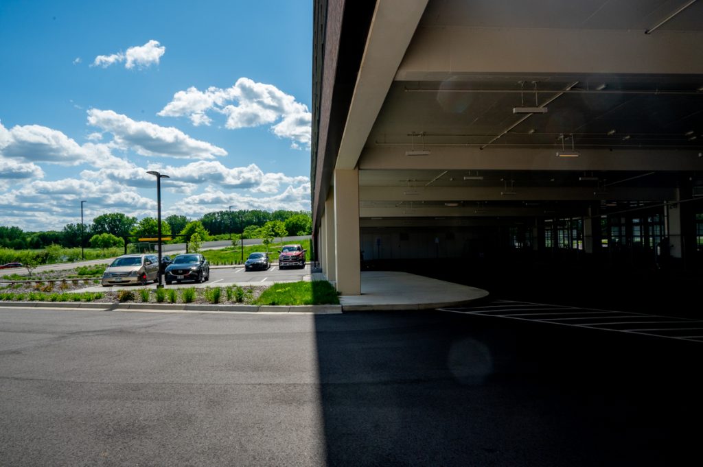 A parking garage and parking lot under blue cloudy skies at SouthWest Station