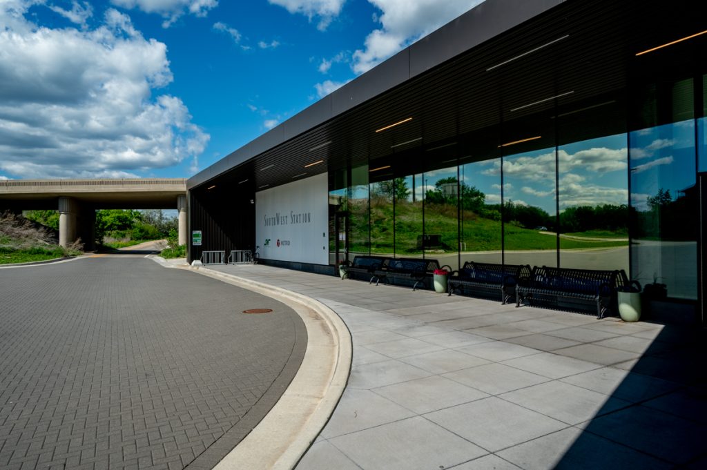 The glass covered entrance reflecting blue cloudy skies at SouthWest Station