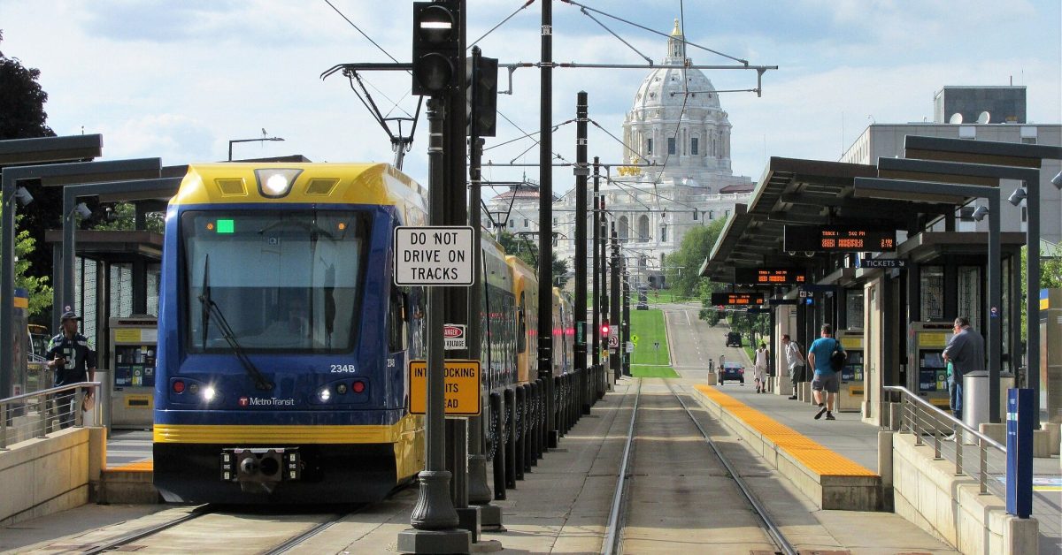 A Green Line train at a station with the capitol building in the background