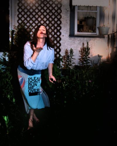 A woman blowing a kiss toward the camera.