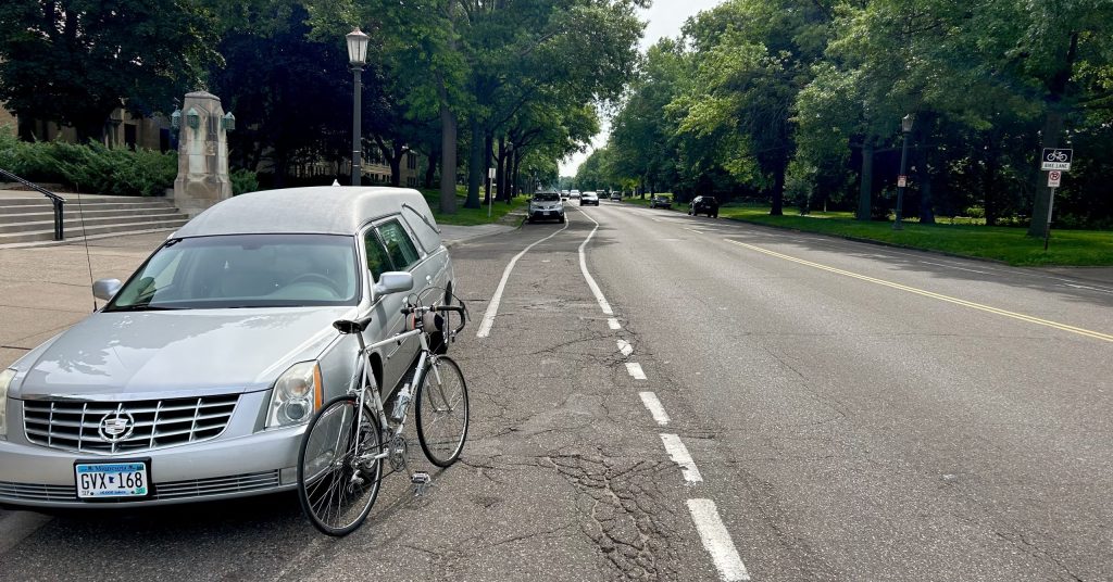 A bike leans against a hearse on Summit Avenue.