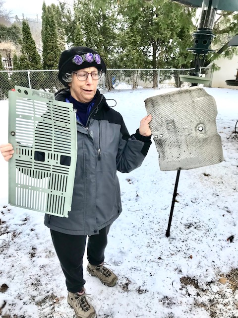 Person holding two pieces of scrap metal