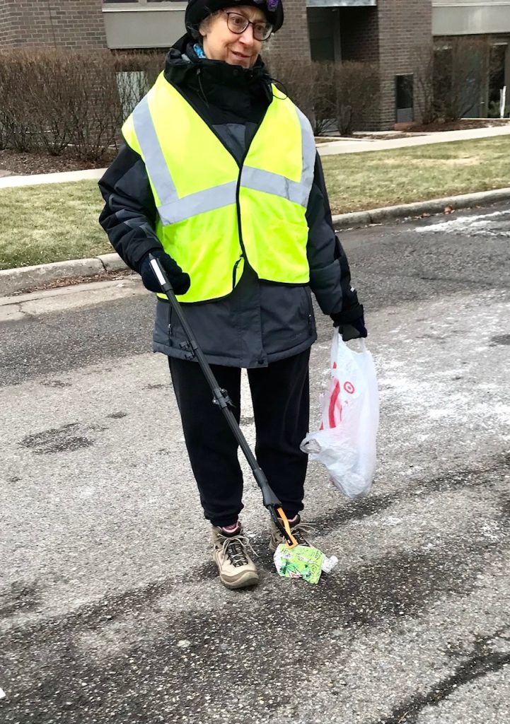 A person in a reflective vest picking up litter
