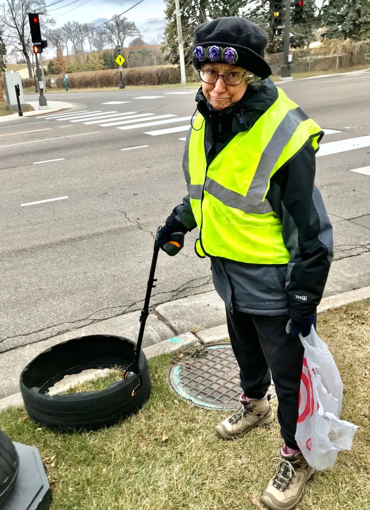 Person in a reflective vest picking up litter
