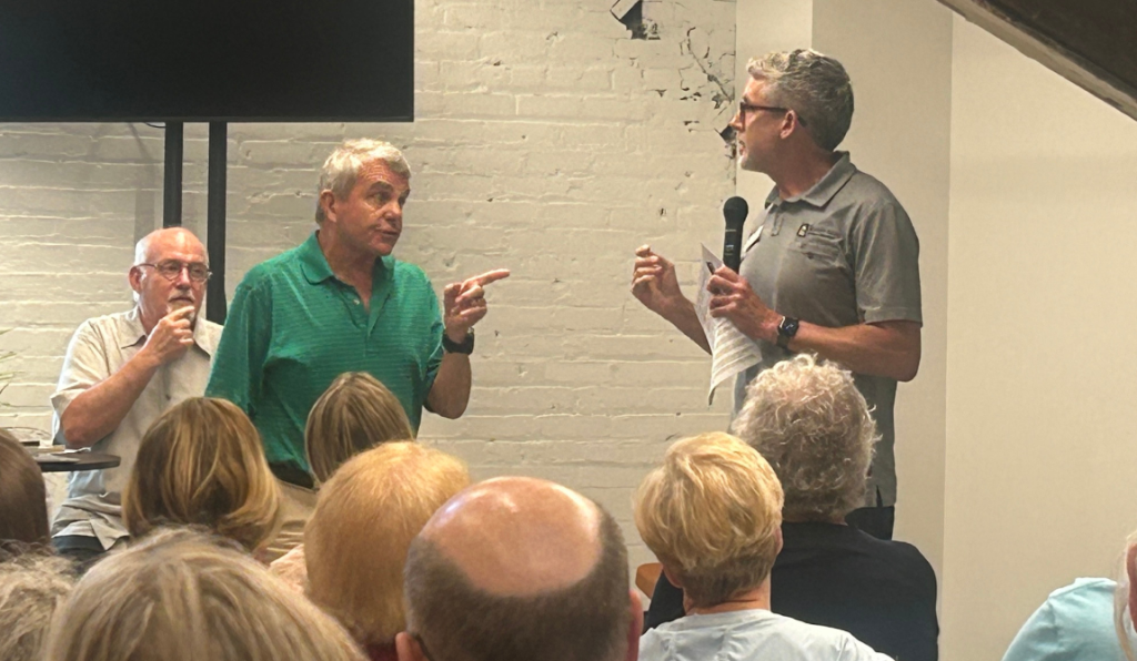 Bob Cattanach of SOS interrupting St. Paul Public Works Director Sean Kershaw shortly before grabbing the microphone away from him.