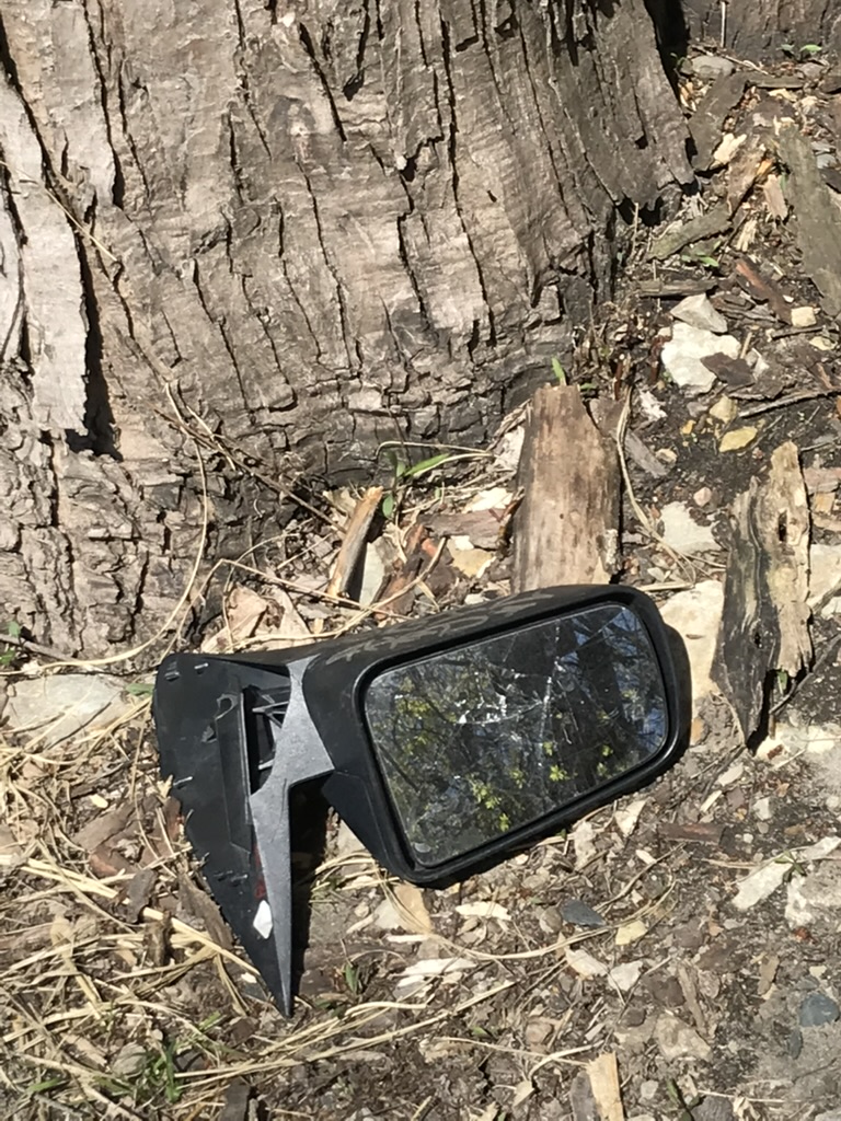 A broken-off car's rearview mirror on the ground